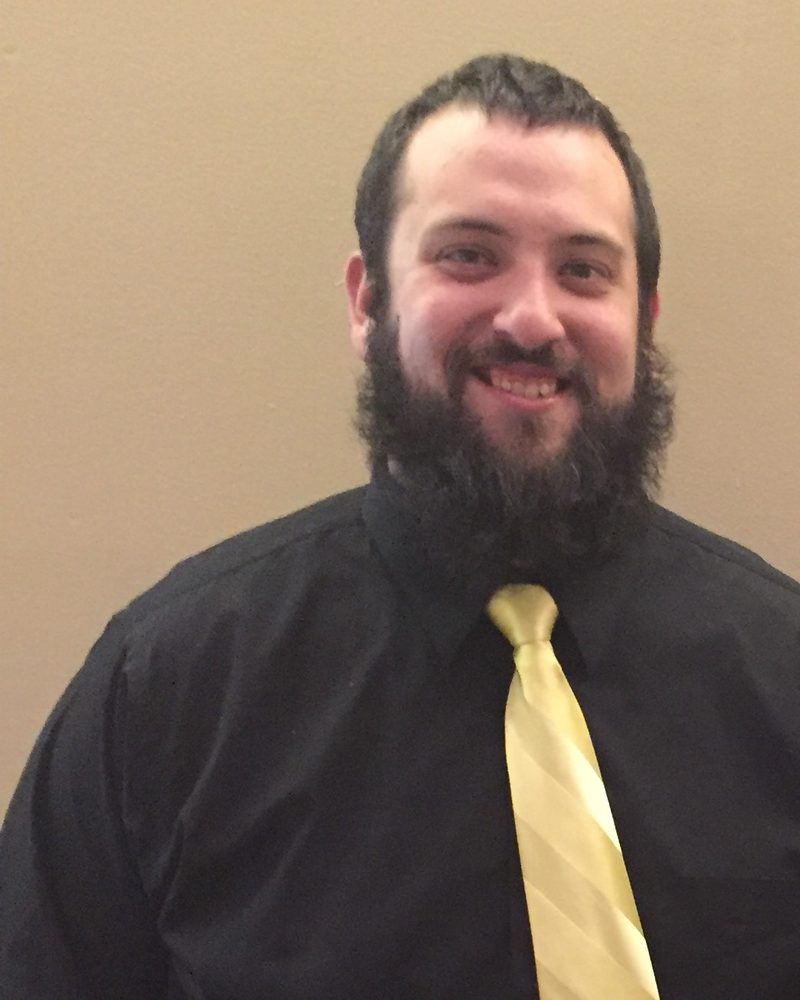 Sal before his weight loss, wearing a black shirt and yellow tie